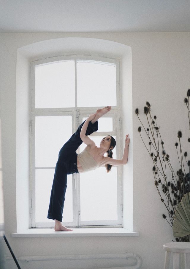 Woman stretching by a window