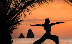 Person meditating at sunset