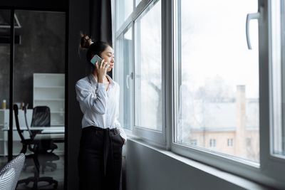 Woman reflecting by a window