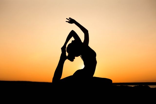 Woman meditating on a cliff at sunrise