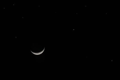 Crescent moon and stars at night