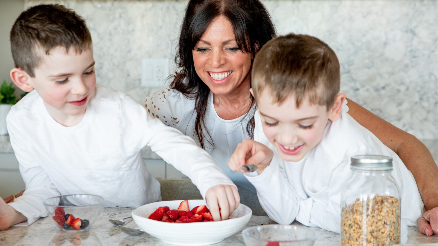 Amy laughing with her two boys in the kitchen