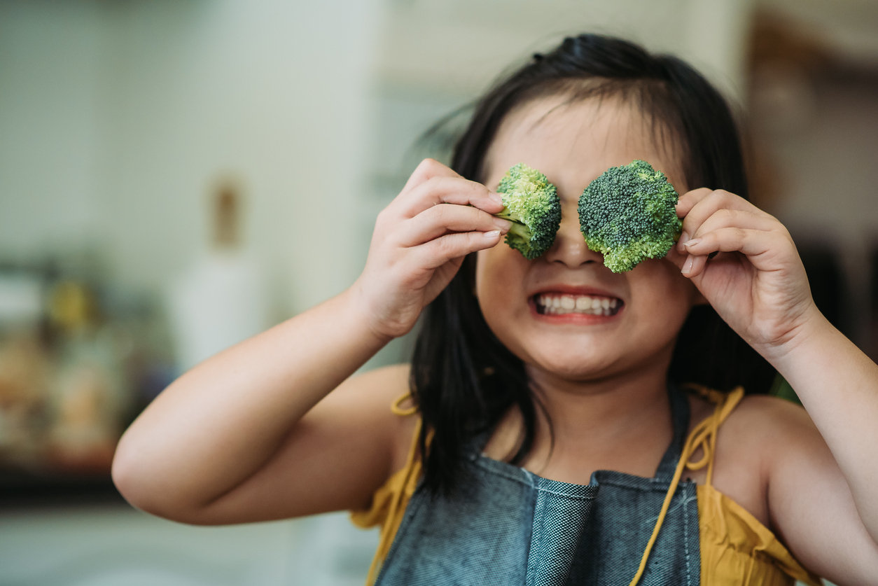 girl holding broccoli
