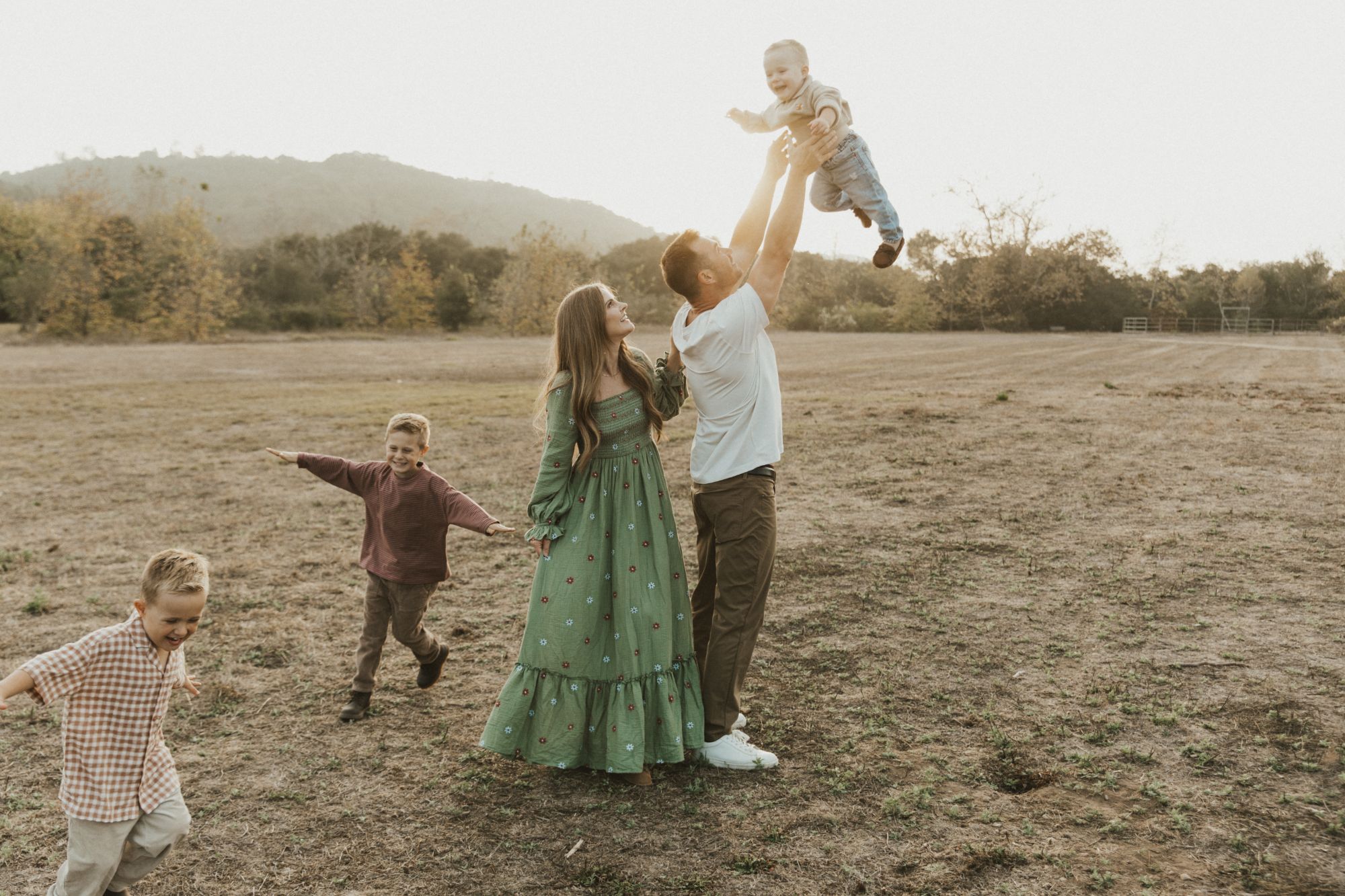 Ashley and her husband lifting their youngest in the air