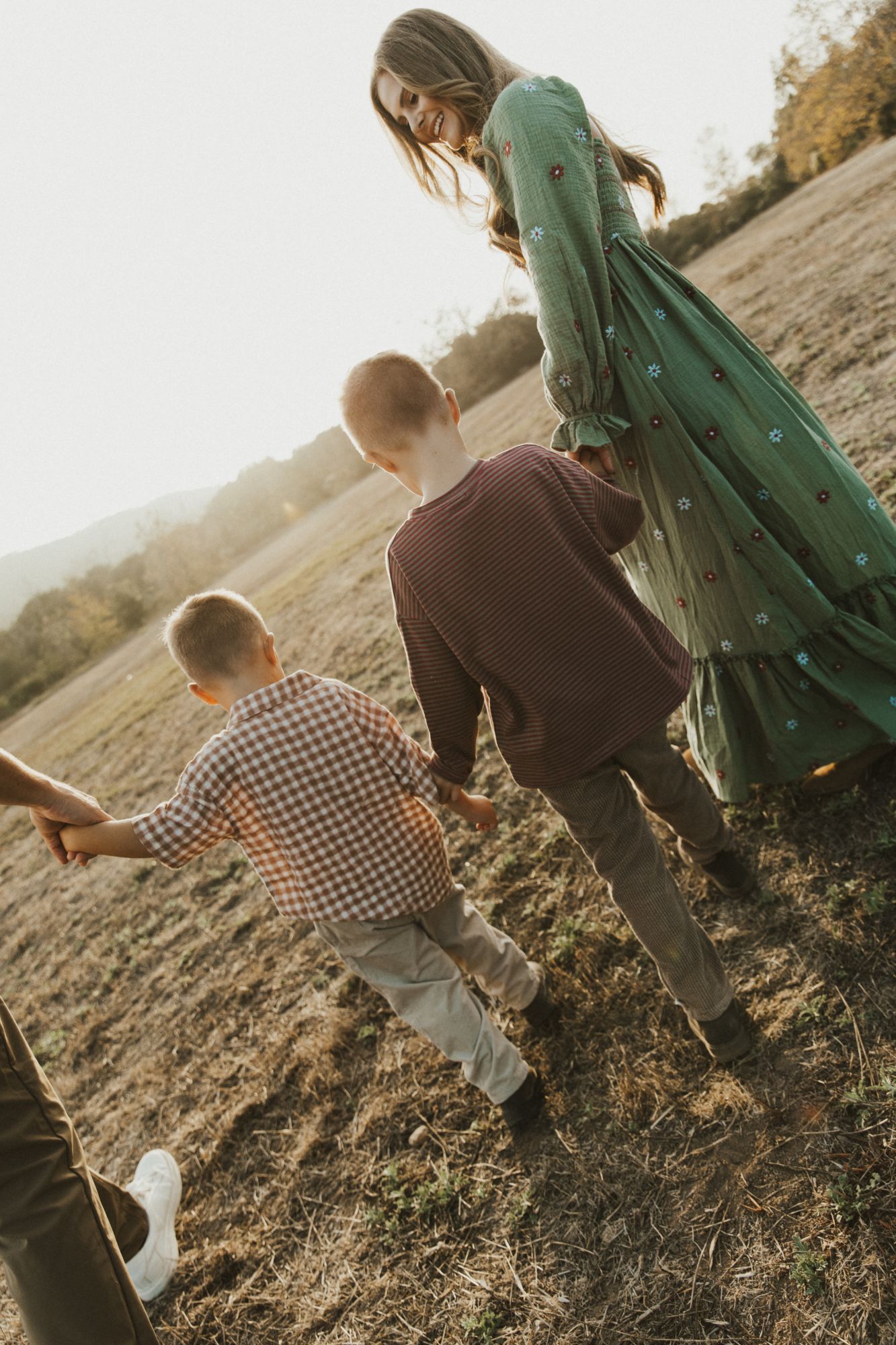 Ashley leading her boys up a hill at sunset