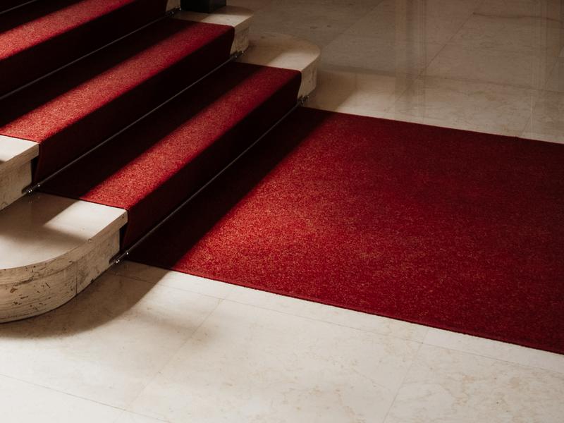 A red carpet on marble hotel stairs