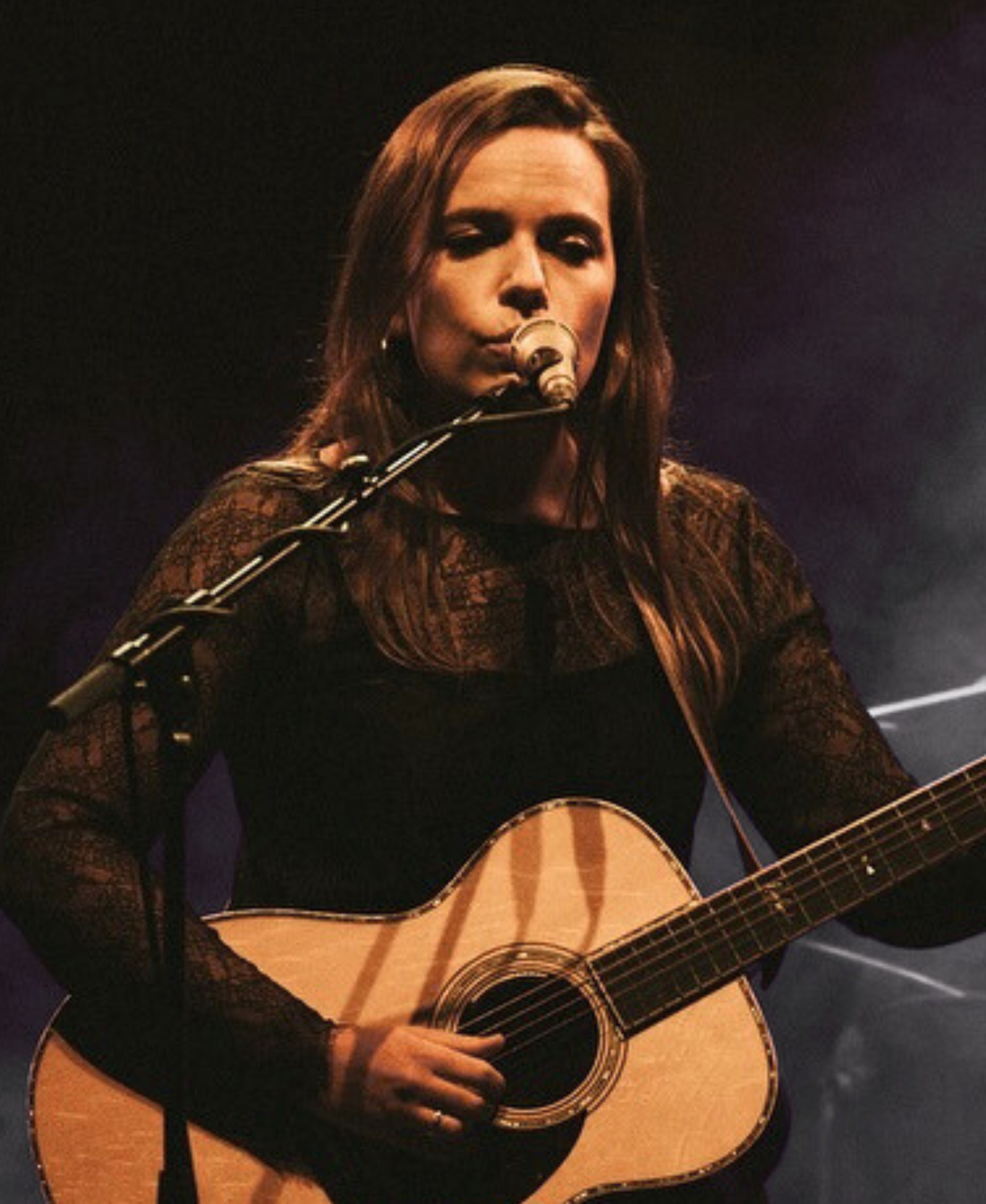 Mary Spender singing with an acoustic guitar