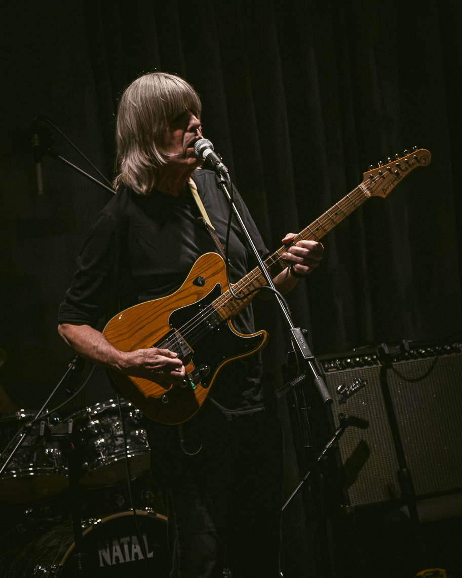 A guitarist performing on stage at the grand finale concert