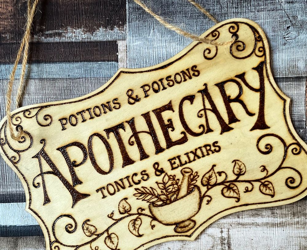 Burned Apothecary wall sign with lettering and vines
