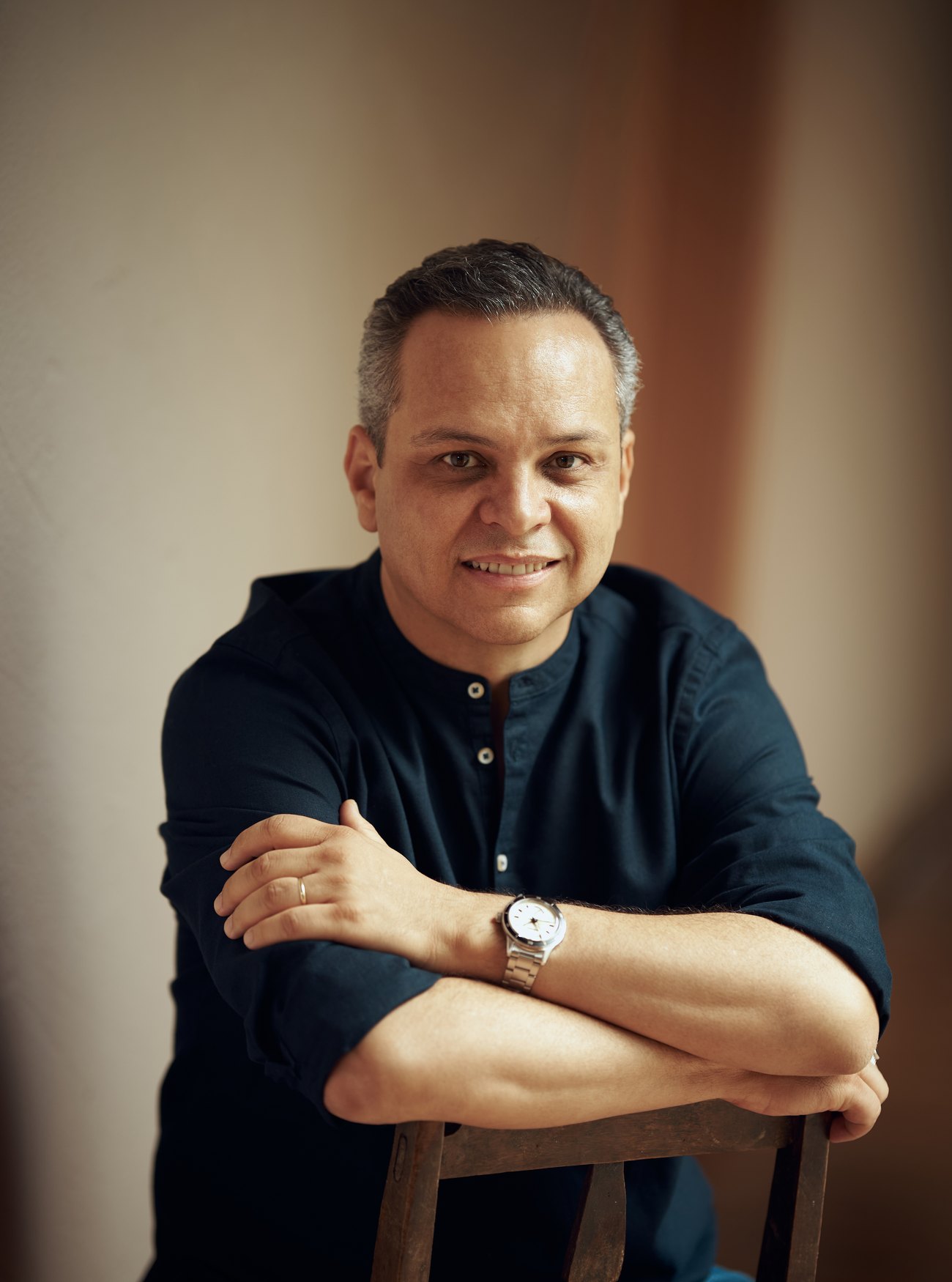 Prof. Arjun, sentado, em retrato com luz quente