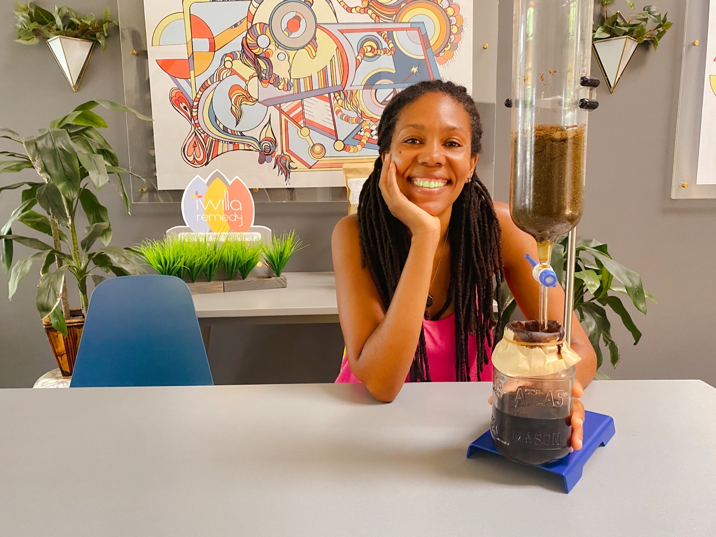 Selima smiling beside an herbal percolation setup