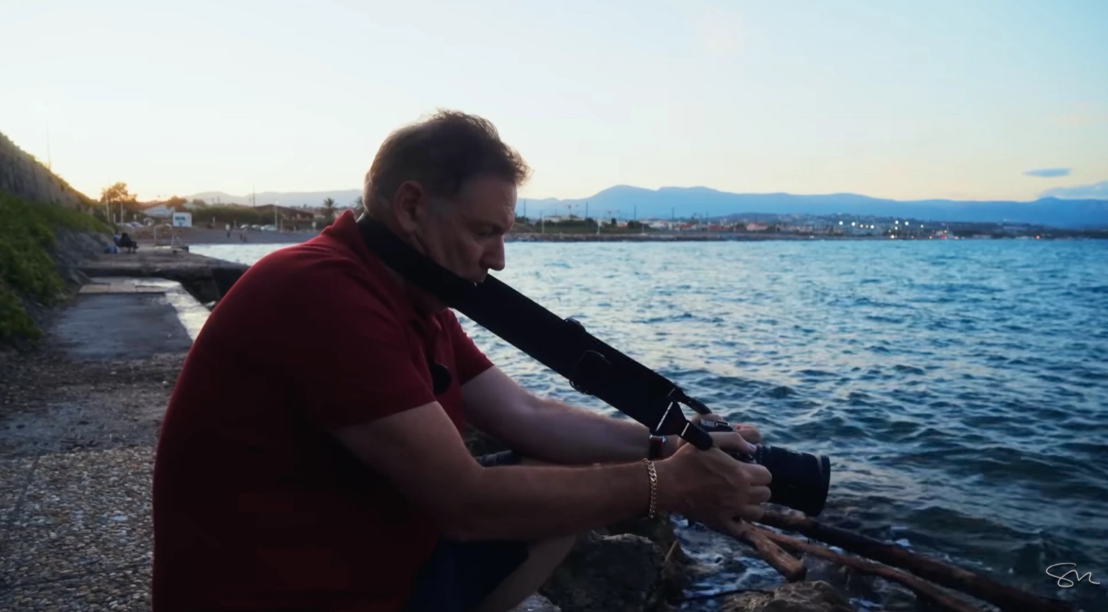 Using the camera strap pulled tight around the neck as an improvised tripod