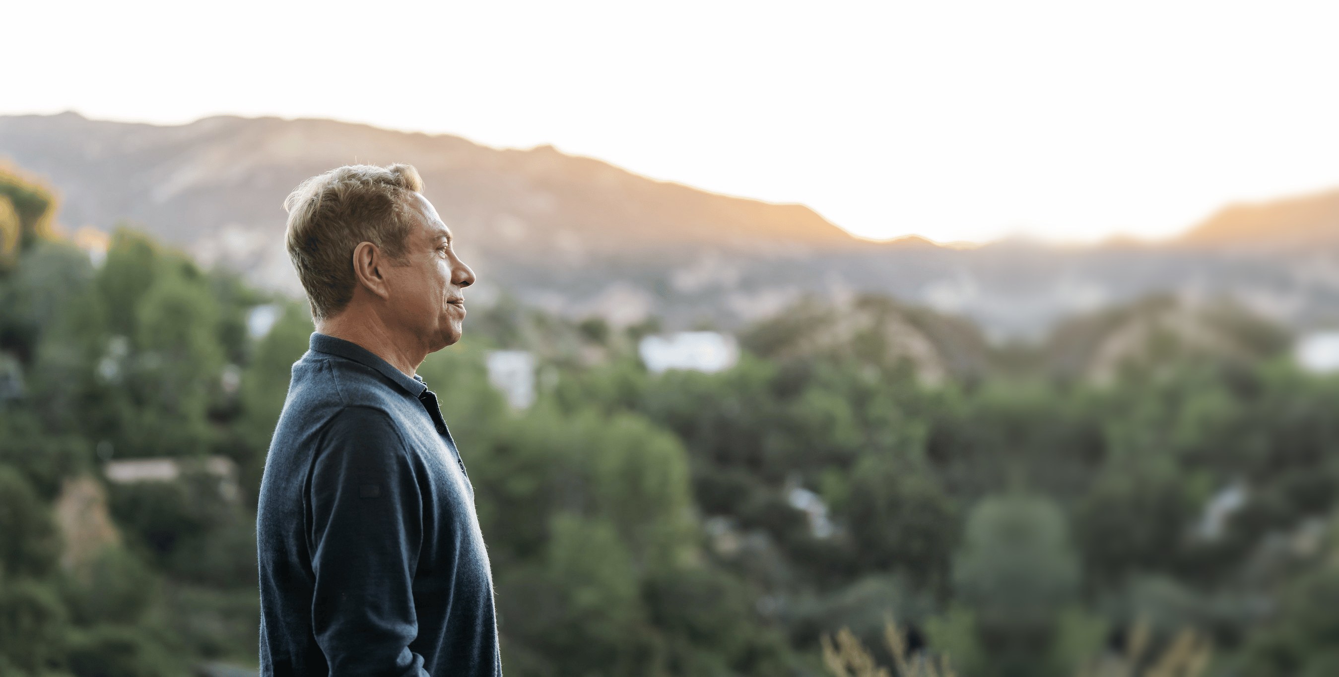 David Kessler looking out over a hillside at sunset
