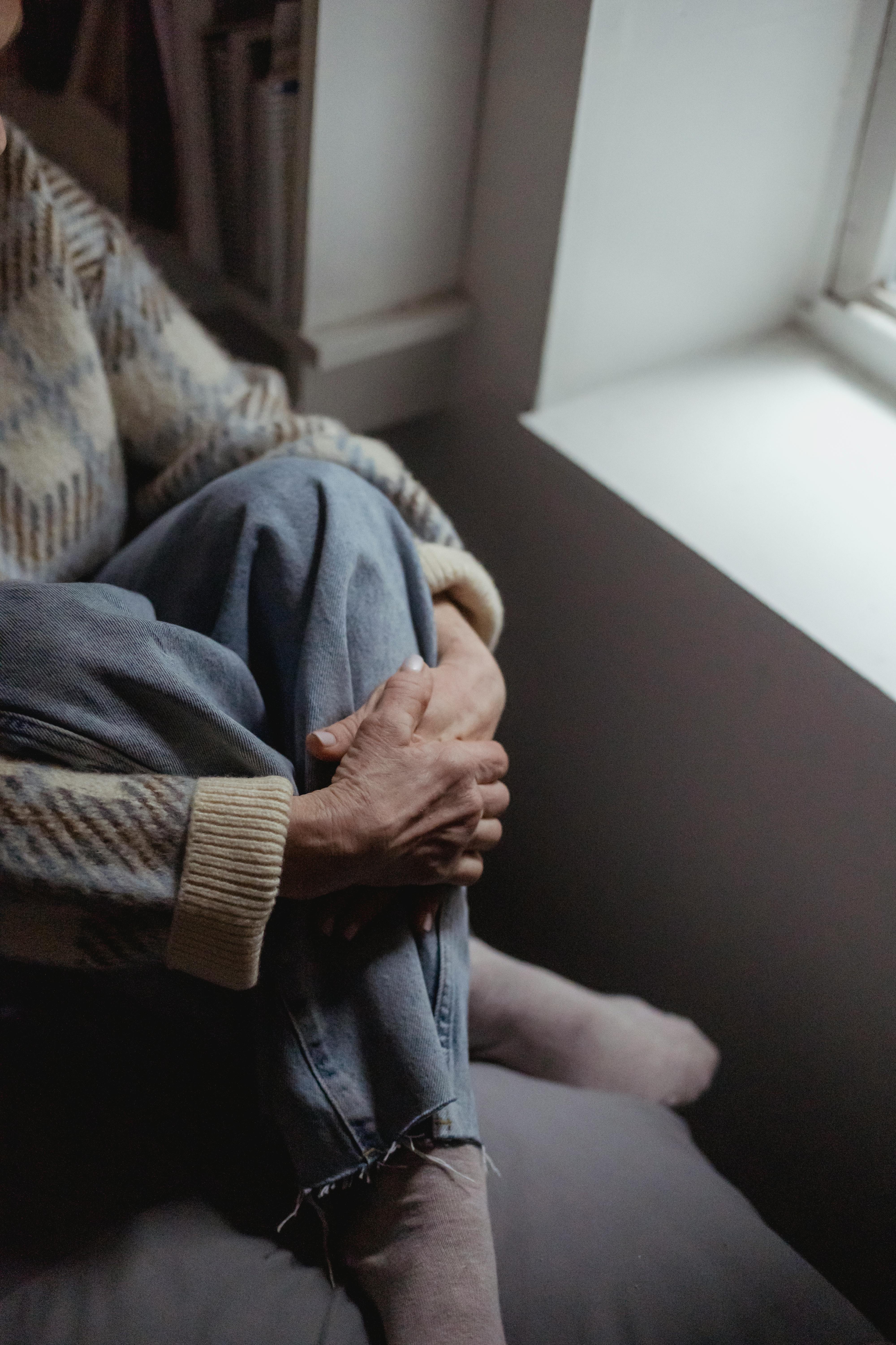 Older woman hugging her knees